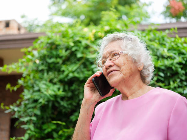 istock Elderly woman using phone outside 1147891429