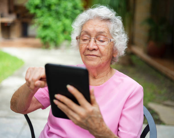 istock Latin senior woman using digital tablet outdoors 1147891441
