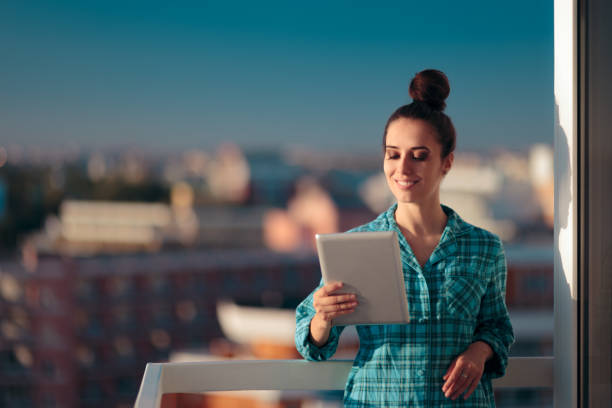 istock Woman in Pajamas with PC Tablet Starting her Morning Routine 1147892781