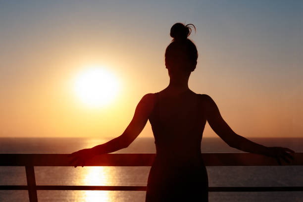 female silhouette at the balcony admiring sunrise - idealist imagens e fotografias de stock
