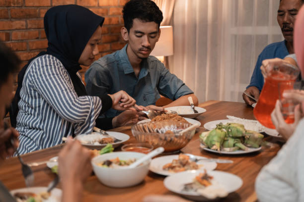 break fasting or buka puasa on ramadan kareem happy asian muslim family dinner together at home. break fasting or buka puasa on ramadan kareem hari raya family stock pictures, royalty-free photos & images