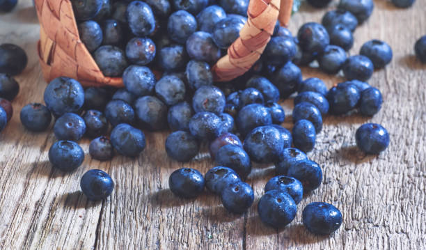 istock Fresh blueberries in wicker basket, vintage wooden table, selective focus 1147899654