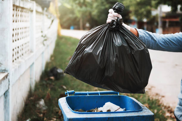 istock hand holding garbage black bag putting in to trash 1147902353