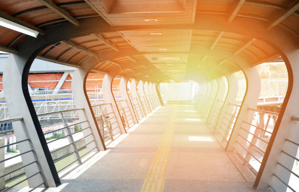 istock pedestrian overpass -  modern footbridge overpass crossing on traffic and river with light at the end 1147902414