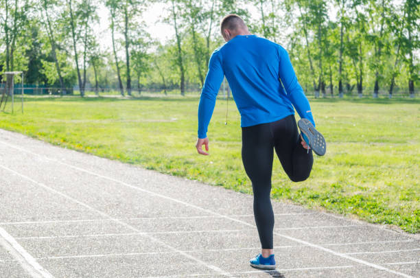istock Young sportsman doing stretching exercise, preparing for morning training 1147903644