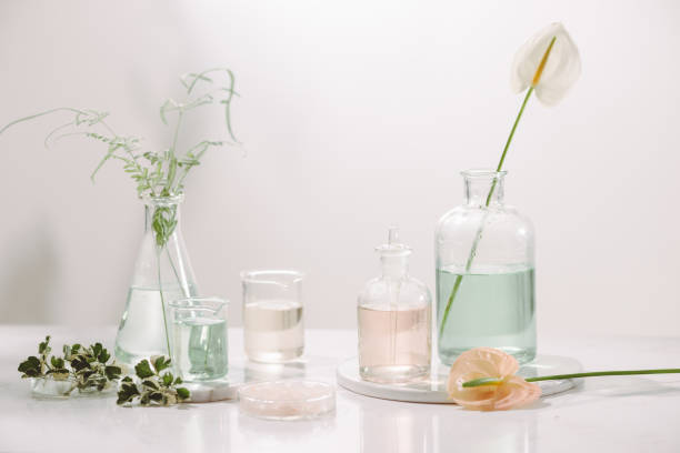 istock Perfume oils concept. Laboratory glassware with infused floral water on table 1147904660