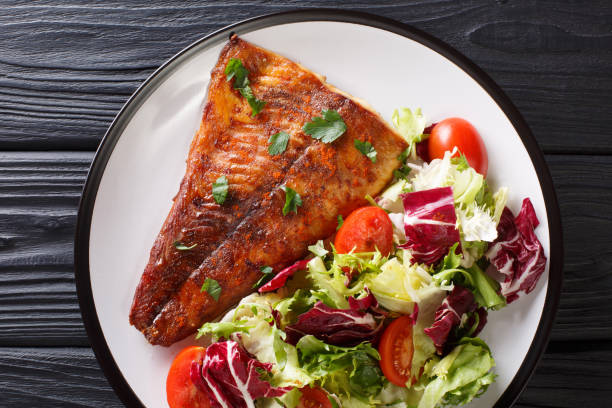 istock Fried pike fillet served with fresh vegetable salad close-up. horizontal top view 1147909740
