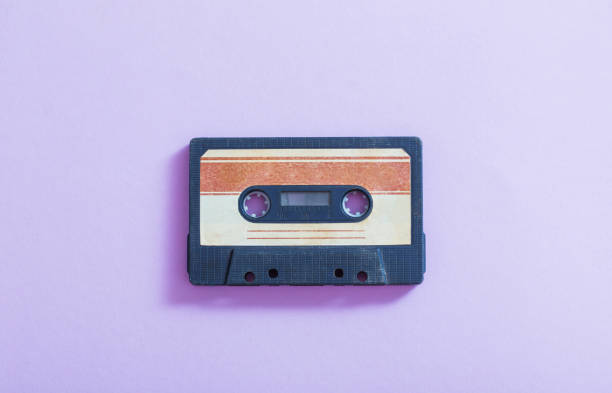istock Old plastic cassette on violet  background. Retro music concept 1147913553