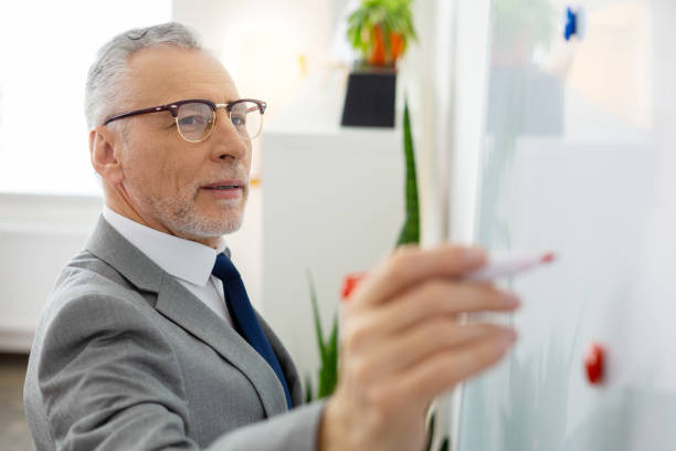 istock Good-looking man with grey stubble carrying marker 1147919123