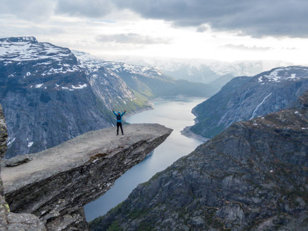 istock Norway - Young man standing at the edge of Trolltunga 1147920028