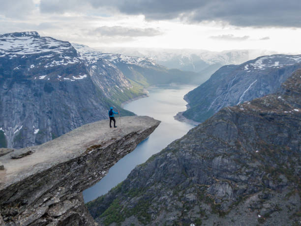 istock Norway - Young man standing at the edge of Trolltunga 1147920054