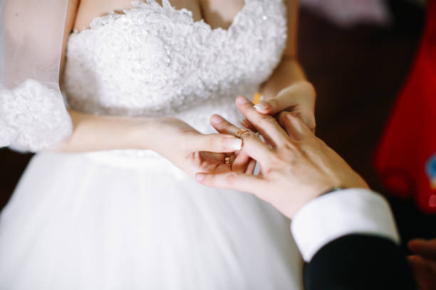 istock Bride putting on a wedding ring for bridegroom 1147923479