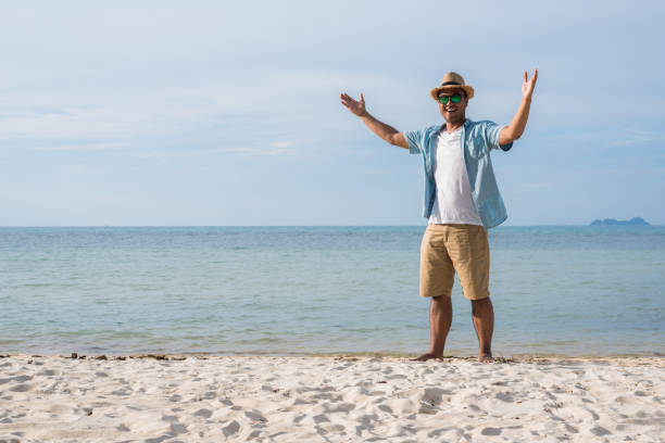 istock Happy young asian man on beach in vacation time. 1147923558