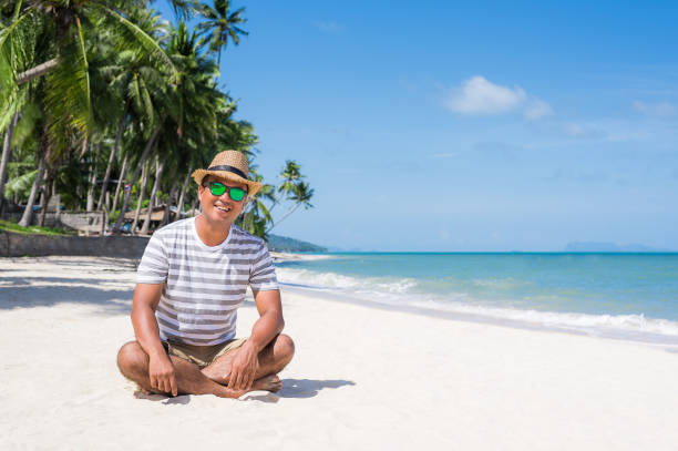 istock Happy young asian man on beach in vacation time. 1147923783