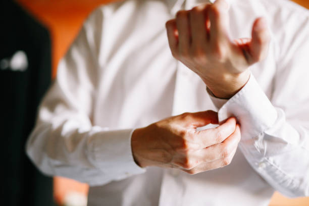 istock Man button up his white shirt sleeve 1147923814