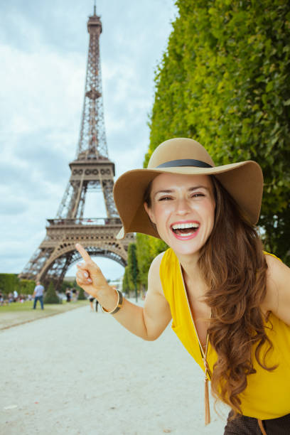 istock smiling young tourist woman pointing at Eiffel tower 1147926222