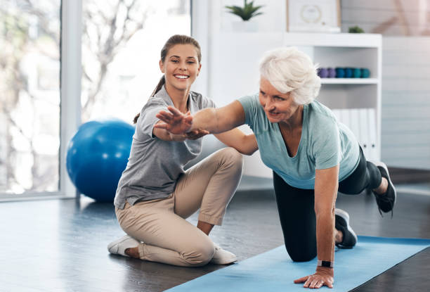 Whatever your age it's important to workout Shot of a senior woman being treated by a physiotherapist serving sport stock pictures, royalty-free photos & images
