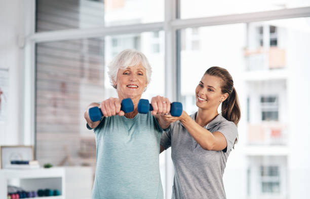 Keeping her muscles supple through the senior years Shot of a young physiotherapist assisting a senior patient with strengthening exercises senior bodybuilders stock pictures, royalty-free photos & images