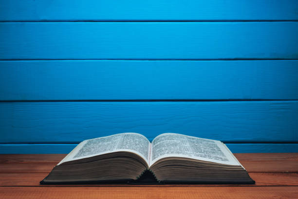 istock Bible on a red wooden table. Beutiful wood blue wall background. 1147931106