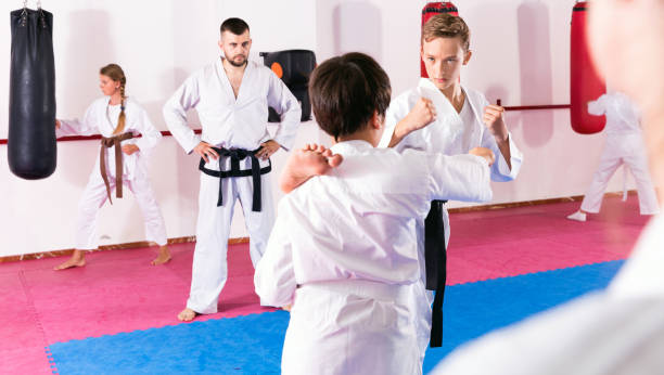 istock Kids in kimonos exercising techniques in pair during taekwondo class at gym 1147931135