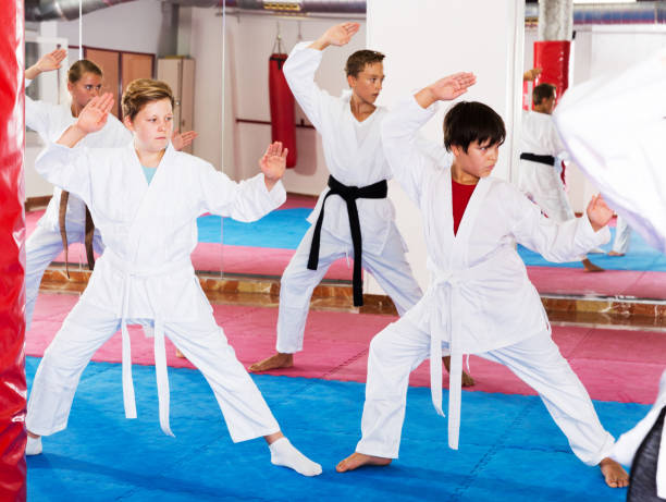 istock Kids exercising karate movements with trainer 1147931148
