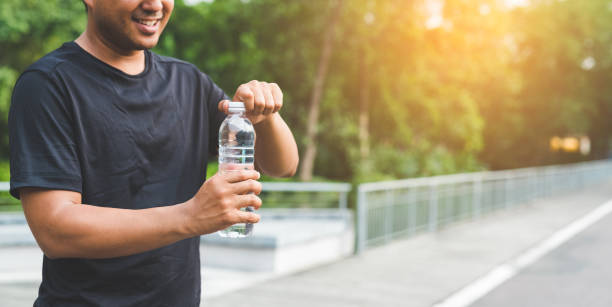 istock Man holding bottle of water 1147931621