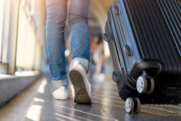 wanita pelancong berjalan sendirian dengan tas koper. perjalanan liburan akhir pekan. - airport potret stok, foto, & gambar bebas royalti
