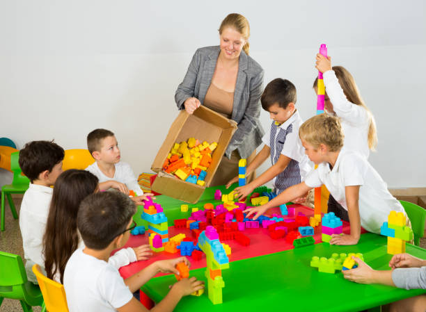 istock Kids and teacher playing with toy building blocks 1147934279