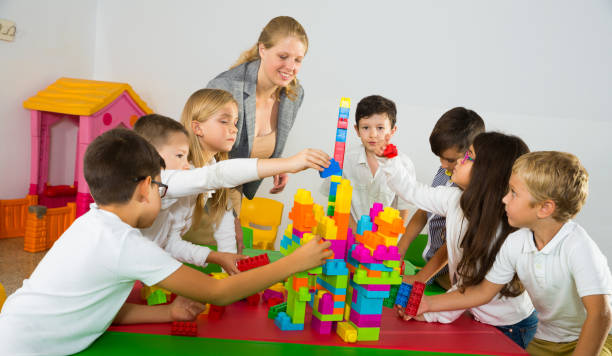 istock Group of schoolkids playing with toy bricks 1147934287