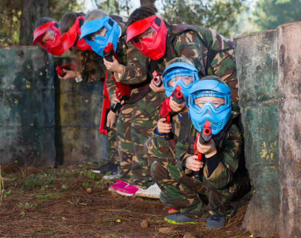 istock Group of cheery kids playing paintball 1147934437