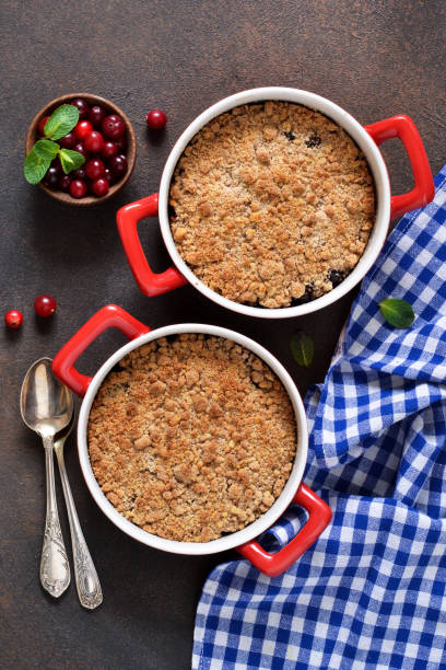 crumble con arándanos y otras bayas, nueces en la mesa de la cocina. vista desde arriba. - apple portion red freshness fotografías e imágenes de stock