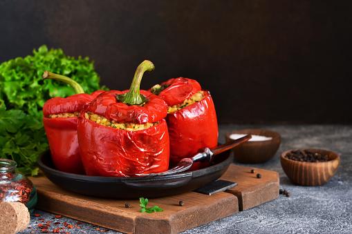 Red pepper stuffed with meat, bulgur and vegetables in a cast-iron pan. Baked stuffed peppers.