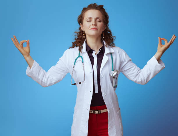 istock relaxed modern physician woman doing yoga on blue 1147942755