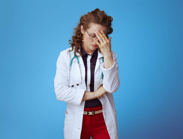 istock tired modern doctor woman on blue 1147943007