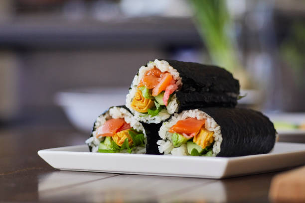 rouleau de riz enveloppé dans une assiette. - maki sushi photos et images de collection