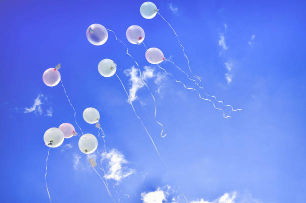 istock Low Angle View Of Helium Balloons Flying Against Blue Sky 1147945934