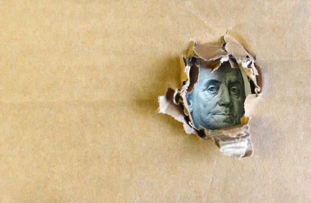 istock One hundred dollar bill concept. Franklin portrait on a hundred dollars bank note through the hole. 1147948820
