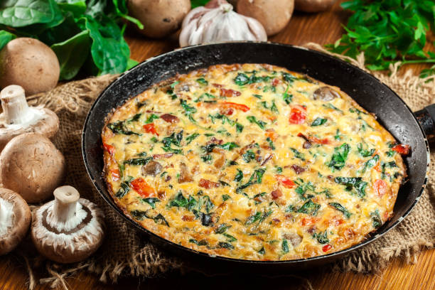 Frittata made of eggs, mushrooms and spinach stock photo