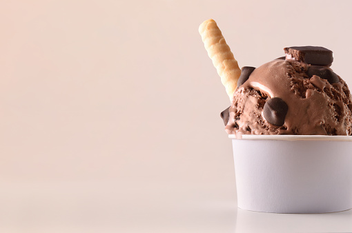 Chocolate ice cream cup on table isolated close up. Horizontal composition. Front view.