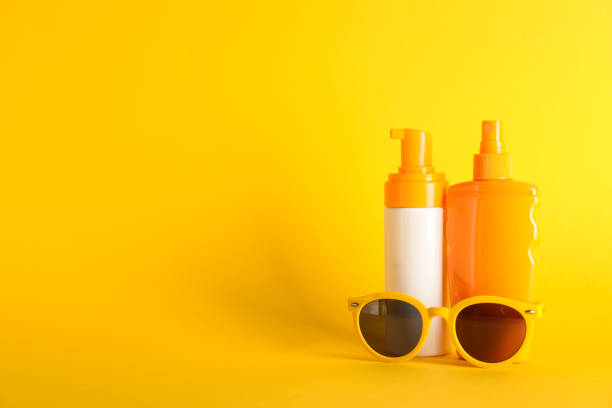 istock Sunscreen sprays with sunglasses on color background, space for text 1147950987
