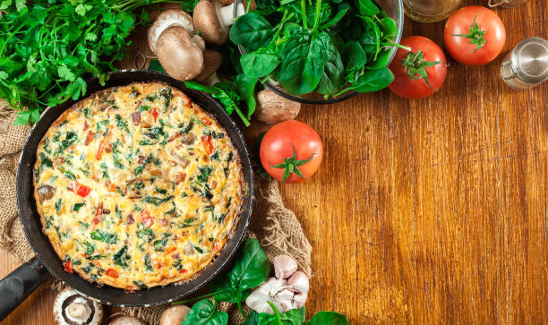 Frittata made of eggs, mushrooms and spinach stock photo