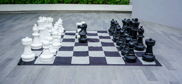 super duży rozmiar czarno-białych elementów gry w szachy, figurki na szachownicy do dekoracji na świeżym powietrzu. - play offense sport plan zdjęcia i obrazy z banku zdjęć