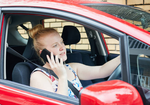 istock Young woman driver talking, illegally, on phone 1147954009