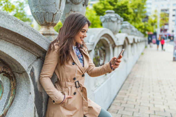 istock Cheerful girl using smartphone in town 1147956495