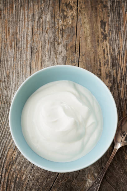 istock Yoghurt in a blue bowl on vintage rustic wooden table from above 1147958492