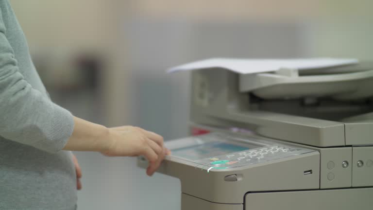 Chinese pregnant office woman using a photocopier