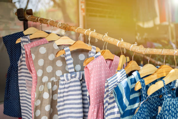 vestido bonito da menina que pendura na vara de madeira - child clothing arrangement hanger - fotografias e filmes do acervo