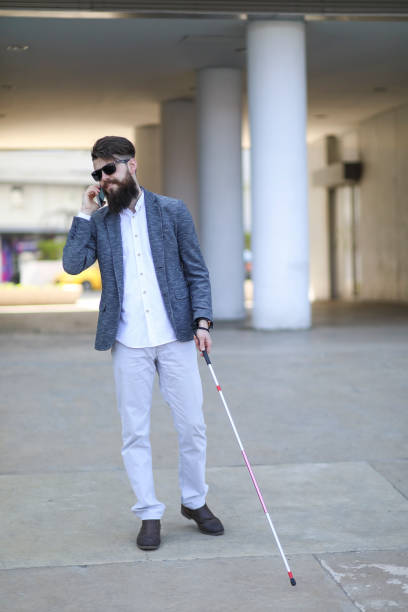 istock Blind and bearded man with a walking stick on the street 1147959945