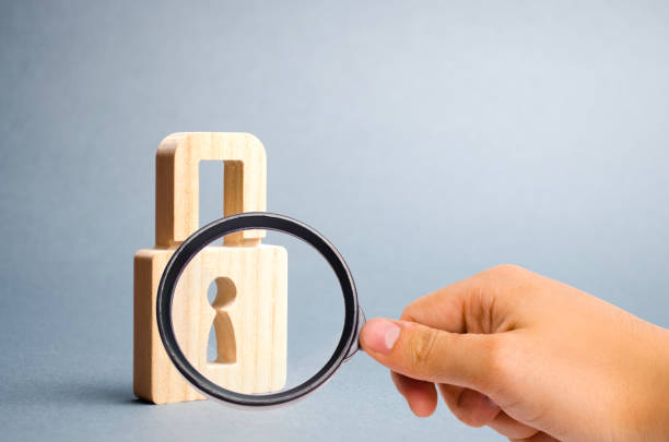 istock Magnifying glass is looking at the padlock on a gray background. information safty. concept of the preservation of secrets, information and values. Protection of data and information. Selective focus 1147960055