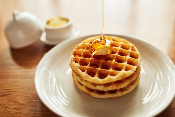 herrlich goldene waffeln - waffle syrup pouring breakfast stock-fotos und bilder